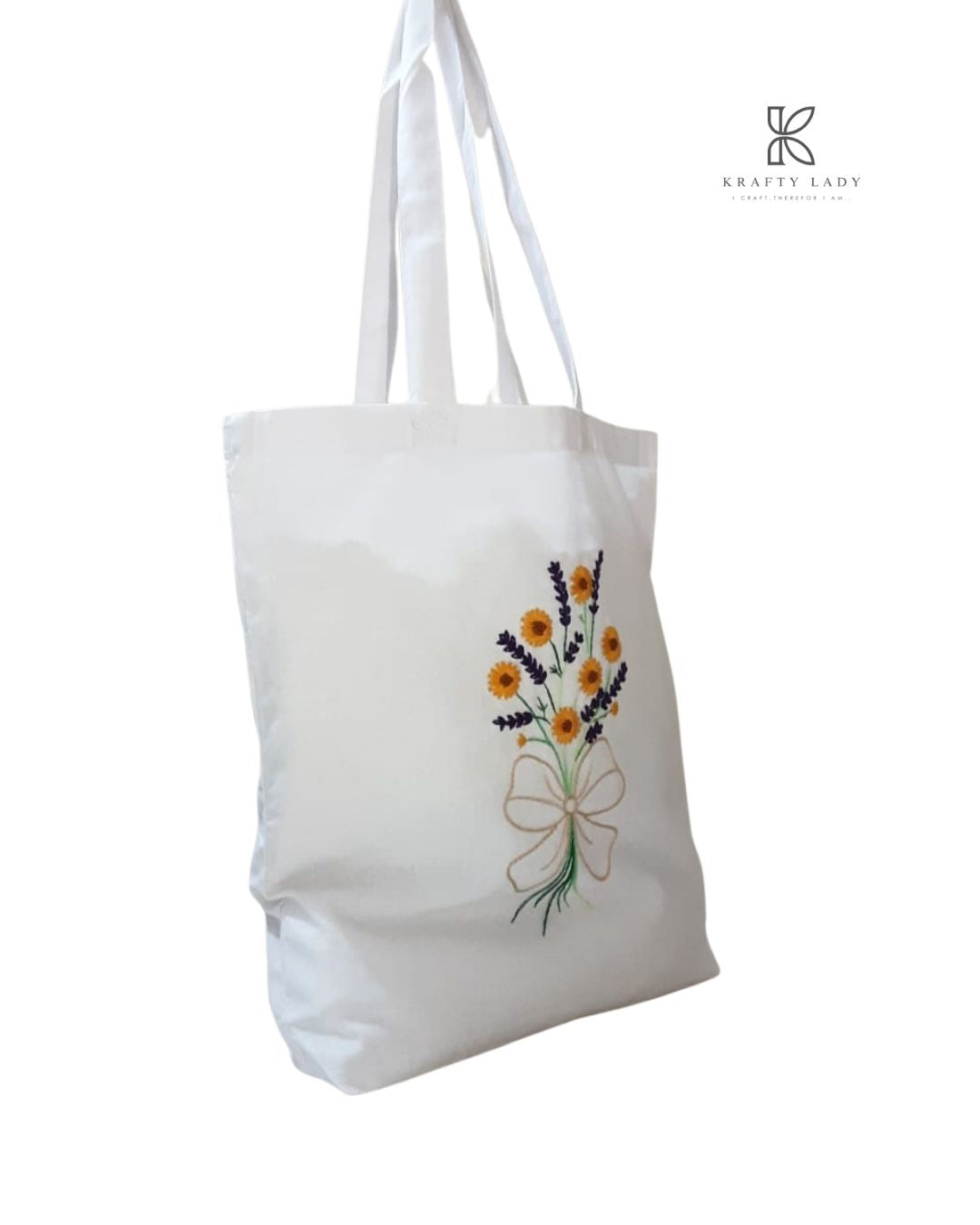 White tote bag with floral embroidery on a white background