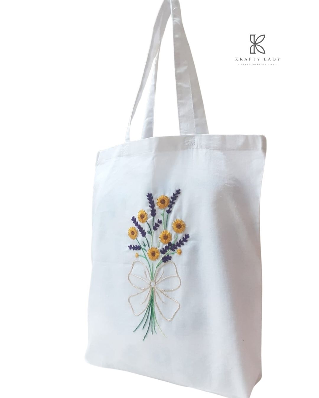 White tote bag with floral embroidery on a white background