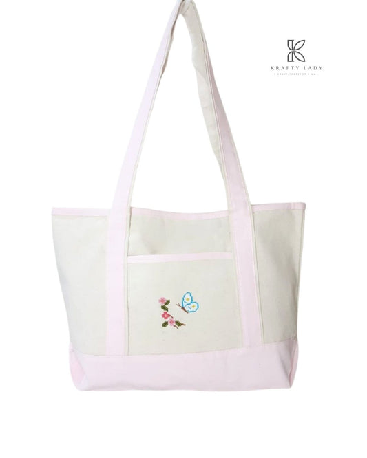 Pink tote bag with floral embroidery on a white background