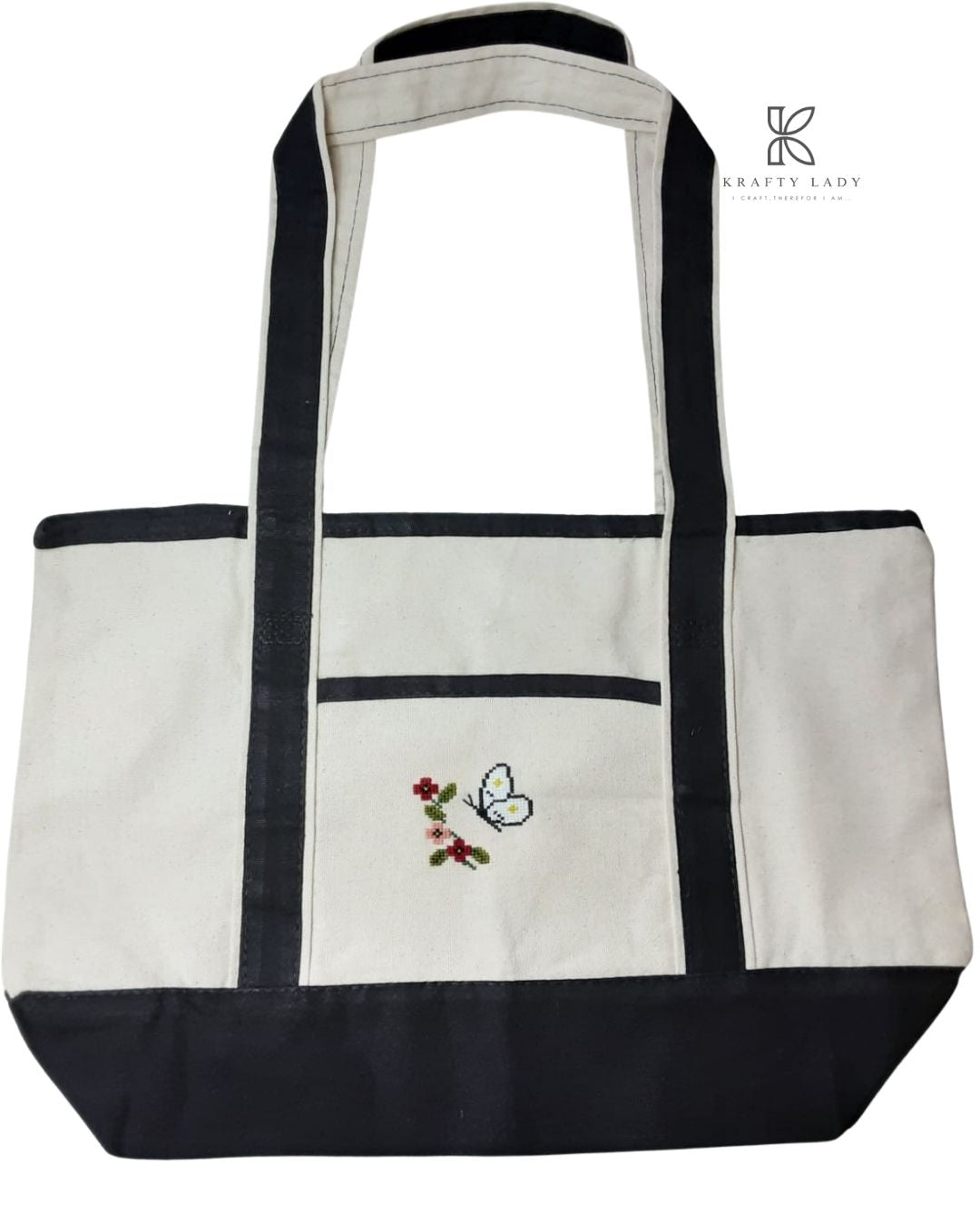 White tote bag with black accents and embroidered design on a white background